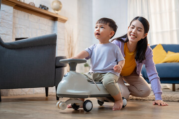 Asian boy playing with a stroller at home