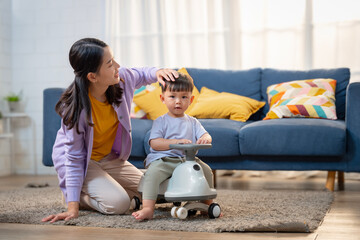 Asian boy playing with a stroller at home