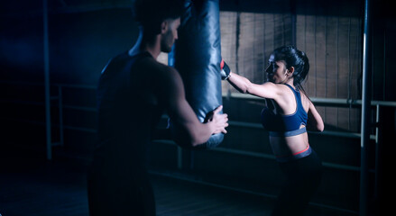 Indian young adult gen z angry fit boxer woman lady wear gloves do hand fist boxing punch beat on...