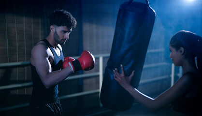 Indian young adult gen z angry fit boxer man guy wear gloves do hand fist boxing punch beat hit on...
