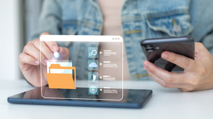 Close up hand using a tablet and smartphone with hologram folder icon. Concept of digital file management, cloud storage, cybersecurity, AI data system, business technology and secure online solution.