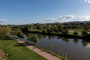 Fototapeta premium Guadiana river flowing through green park in merida, spain