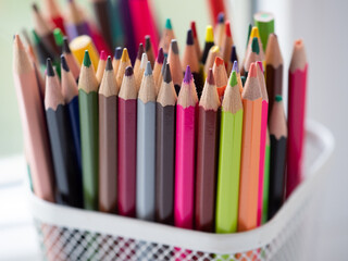 Fototapeta premium Close-Up of Vibrant Collection of Colorful Colored Pencils in a pen holder. Creative Art. Colourful assortment of sharpened colored pencils for art projects, drawing, and creativity. Artist's studio