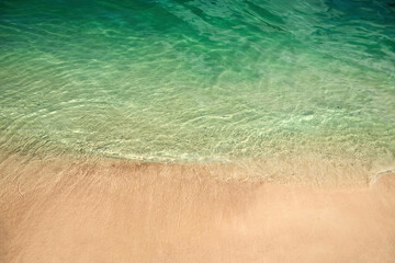 Tranquil Shoreline. Clear turquoise water gently laps against a sandy beach.