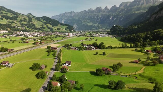 Scenic Aerial View of a Valley with Green Fields and Mountain Landscape in Switzerland near Flums, Berschis, and Walenstadt in the Canton of St. Gallen &ndash; Drone Footage