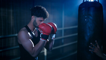 Indian young adult gen z angry fit boxer man guy wear gloves do hand fist boxing punch beat hit on...