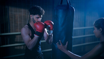 Indian young adult gen z angry fit boxer man guy wear gloves do hand fist boxing punch beat hit on...