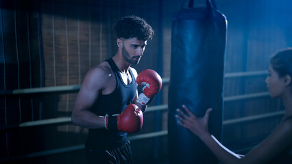 Indian young adult gen z angry fit boxer man guy wear gloves do hand fist boxing punch beat hit on...