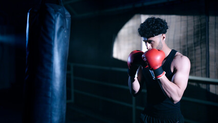 Indian young adult gen z angry fit boxer man guy wear gloves do hand fist boxing punch beat hit on...