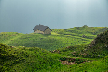 Lonely mountain house on green hills