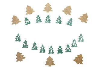 Merry Christmas sign with cutouts of green trees and golden pine trees around on white background