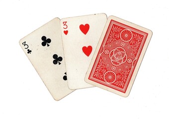 A hand of three vintage playing cards with two cards revealed on a white background.
