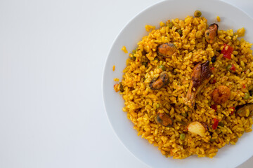 Paella con pollo e frutti di mare in piatto bianco