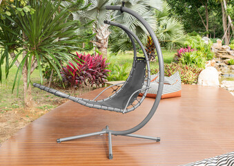 Outdoor gray woven rattan swing at backyard