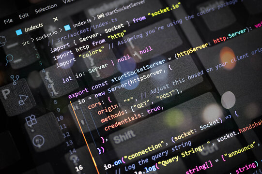 Close-up of colorful TypeScript code for server and socket connection overlayed on a computer keyboard. Perfect for web developers, programmers, tech blogs, coding, and software development content.