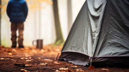 Contemplating morning nature alone with oneself is a separate type of happiness. Male hiker thoughtfully enjoys a morning mug of coffee near his tent, alone with nature.