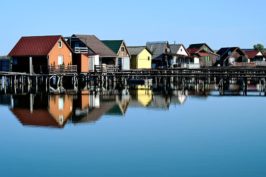 floating fishing village waterscape. fishing huts on wood piles in Bokod, near Oroszlany, Hungary. artificial lake. calm, still water surface with reflection. architecture, travel and tourism concept 