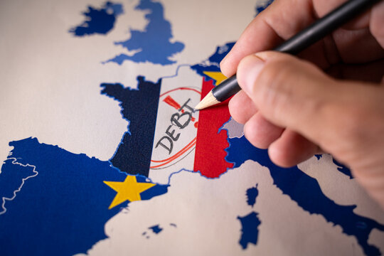 Hand drawing DEBT over a map of France with its national flag, surrounded by the European Union map. Symbolizing the French economic crisis, national debt, and the potential Frexit scenario within the