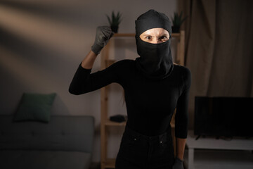Burglary, robbery, theft and crime Concept. Angry Female thief or intruder wearing black balaclava...