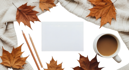 Blank card surrounded by autumn leaves and cozy setting on table