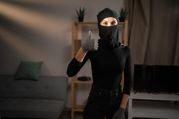 Burglary, robbery, theft and crime Concept. Female thief or intruder wearing black balaclava...