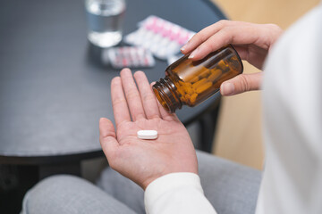 Sick ill asian young woman, girl hold tablet pill on hand pour capsule from medication bottle,...
