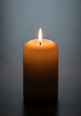 Single lit candle on plain background