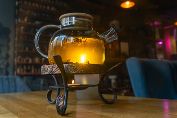 Golden hour tea ritual featuring herbal tea in a glass teapot symbolizing harmony warmth and shared moments of joy. Tranquil tea moment with herbal infusion in a clear teapot surrounded.