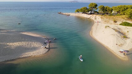 Woman on supboard at Port Glarokavos beach and sea, Kassandra Halkidiki, Greece. Stand up paddle board woman paddle boarding. Aerial panoramic drone view from above, top view from drone.
- Powered by Adobe