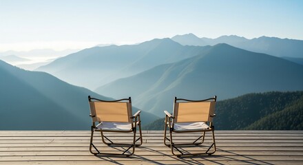 Two empty folding chairs face a scenic vista of layered mountains under a clear sky, inviting relaxation and contemplation.