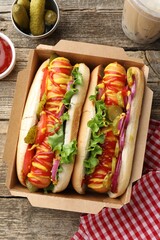 Tasty hot dogs with vegetables, mustard, ketchup and bubble tea on wooden table, flat lay