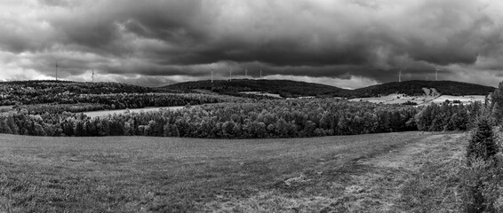 Black clouds over wind turbines in a panoramic landscape