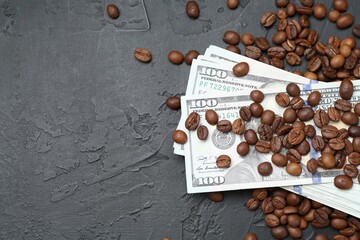 Dollar banknotes and roasted coffee beans on dark textured table, flat lay. Space for text