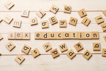 Words Sex Education made of squares with letters on wooden table, flat lay