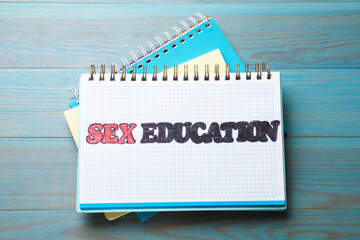 Notebooks with phrase Sex Education on blue wooden background, top view