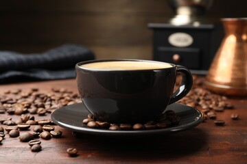 Aromatic coffee in cup, beans, cezve and grinder on wooden table, closeup