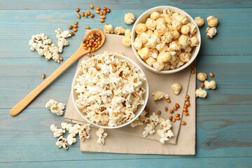 Tasty popcorn and corn kernels on light blue wooden table, flat lay