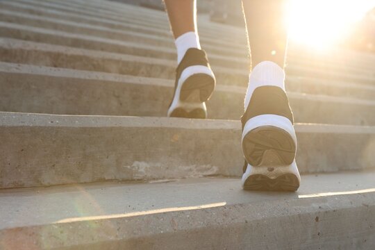 Teenage boy running up stairs outdoors, closeup