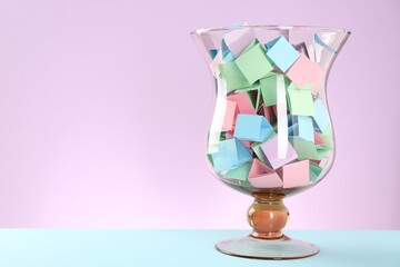 Bright paper pieces in glass jar on color background. Space for text