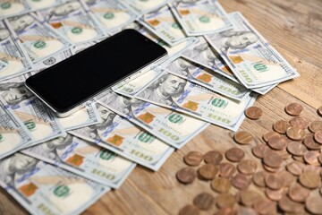 Smartphone and money on wooden table, closeup