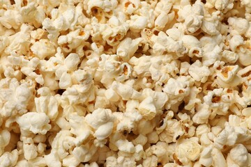 Fresh tasty popcorn as background, closeup view