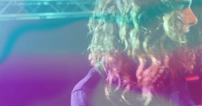 Performing side-profile musician glowing under neon lights on stage, with steel truss, copy space - Powered by Adobe