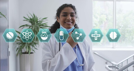 Standing doctor in lab coat adjusting stethoscope and mask in clinic corridor with medical icons