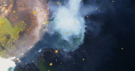 Plunging waterfall spilling over mossy cliff rocks in rocky canyon, swirling mist and yellow stars