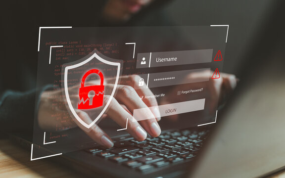 Hacker hands typing on laptop with broken security shield, login interface and programming code. Cybercrime concept showing password cracking, credential theft and unauthorized system penetration.