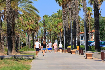 Strollers on a palm path in Salou city, Paseo Jaume I,  Tarragona, Spain. © Aygul Bulté