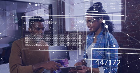 Two tech professionals reviewing data on tablet at open-plan office, with data overlay