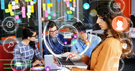 Collaborating professionals typing on laptops at office workstation with digital icons, copy space