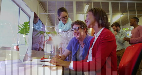 Leaning three colleagues analyzing financial charts on monitor in open plan office, with smartphone