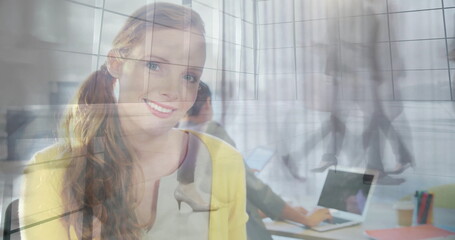 Smiling woman wearing yellow blazer blending with office glass wall, with laptop and coffee cup
